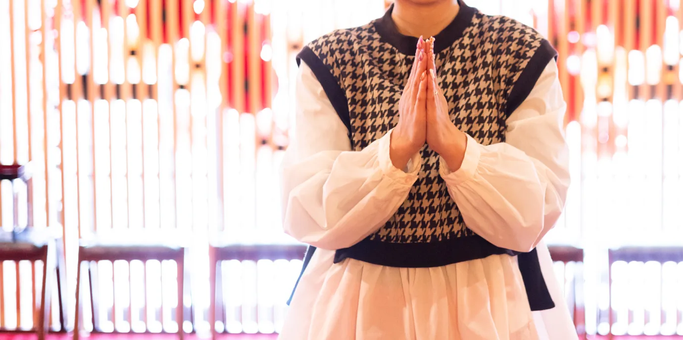 本堂で手を合わせ安産を祈る女性