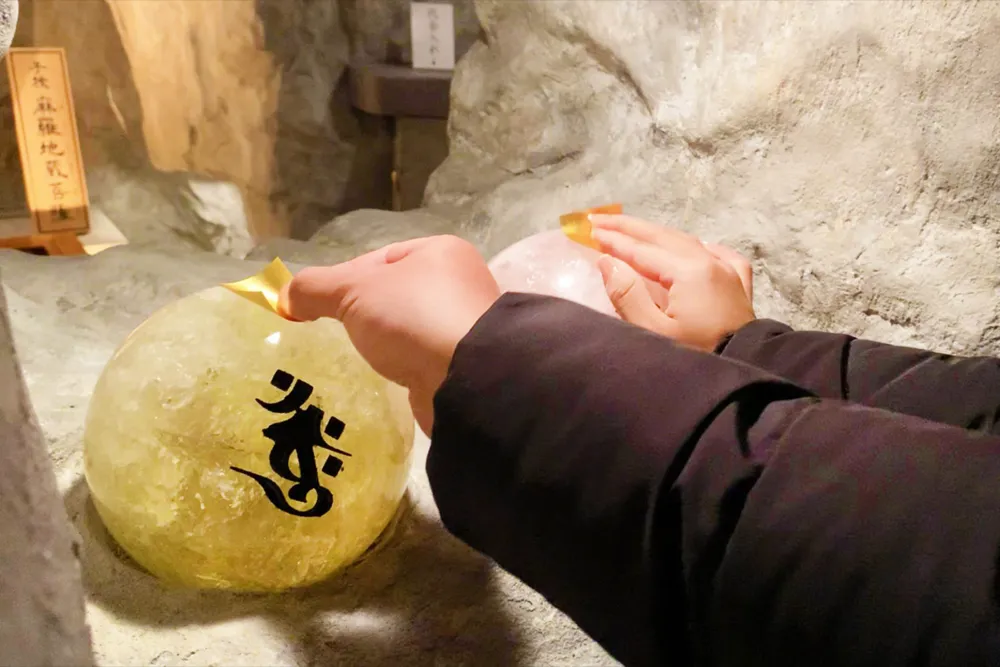 双玉に純金箔を貼り付けて祈願する様子