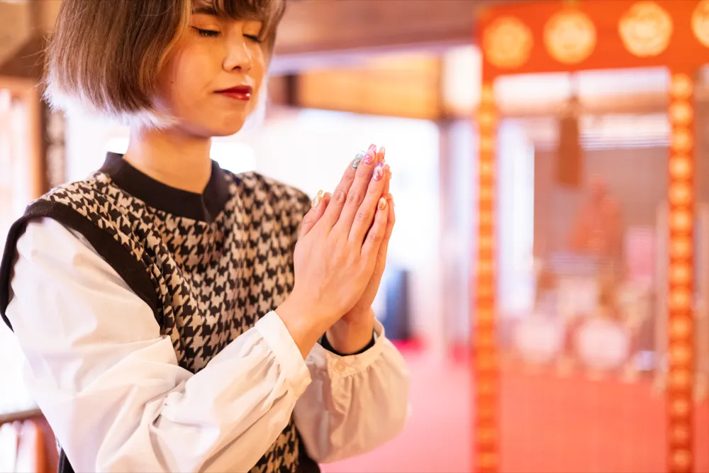 双玉に手を合わせて祈る参拝者